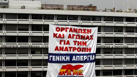 Une banderole "Organisez-vous et luttez pour un renversement. Grève générale" déployée par le syndicat communiste grec Pame sur la façade du ministère des Finances, à Athènes. La Grèce recevra sans doute en juillet une nouvelle tranche d'aide de la part d