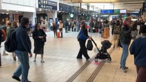 Des voyageurs et une poussette avec un enfant gare Montparnasse à Paris. (Illustration)