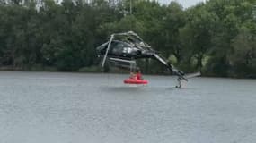 Un hélicoptère bombardier d'eau extrait d'un étang le 26 août 2025 après un crash à Rosporden dans le Finistère