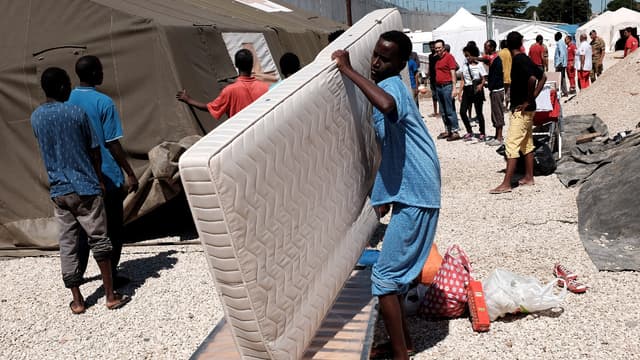 Un migrant transporte un matelas à son arrivée en gare de Tiburtina à Rome, le 20 août 2015