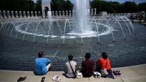 Des personnes assises sur le bord d'une fontaine à Washington (États-Unis), le 19 juin 2024.