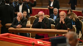 Un prélat fait un geste alors que le corps du défunt pape François repose dans l'état à l'intérieur de la basilique Saint-Pierre au Vatican, le 23 avril 2025. 