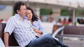 Un couple assis sur un banc.