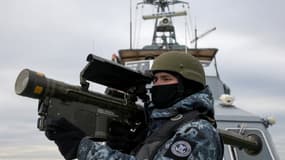 Un soldat ukrainien manipule une arme antiaérienne sur un navire des garde-côtes en mer Noire, le 18 décembre 2023