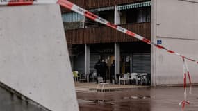 Cette photographie montre un cordon de policiers bloquant le passage alors que des policiers montent la garde devant le bar Aksehir où une grenade a été lancée, dans le village olympique de Grenoble, faisant partie du quartier de La Villeneuve, à Grenoble, le 13 février 2025. 
