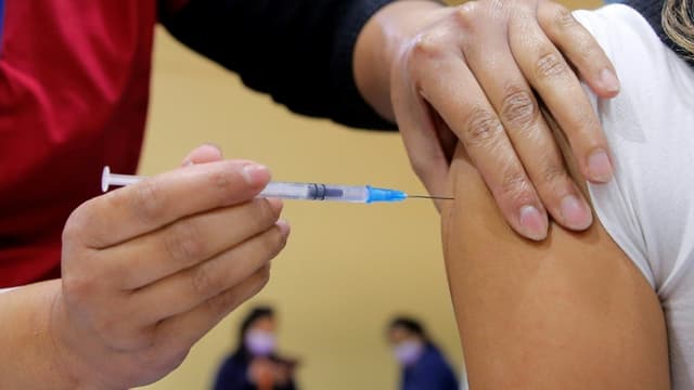 Une infirmière injecte une dose du vaccin chinois CanSino à une femme à Santiago du Chili, le 3 juin 2021.