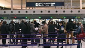 Des voyageurs préparent les documents à présenter au contrôle aux frontières à l'aéroport de Roissy Charles-de-Gaulle, le 1er février 2021