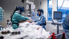 Une photo prise le 27 novembre 2020 montre les sœurs Inika (R) et June Flaa travaillant avec un patient atteint de Covid-19 à l'unité de soins intensifs de l'hôpital universitaire d'Oslo Rikshospitalet à Oslo, en Norvège.