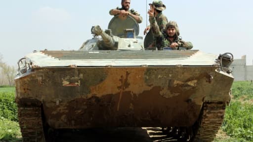 Des membres des forces progouvernementales syriennes dans un tank, le 10 mars 2018 à Aftris, dans la Ghouta orientale