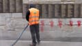 Un agent nettoie les tags sur le Mur des Justes, le 14 mai 2024 à Paris