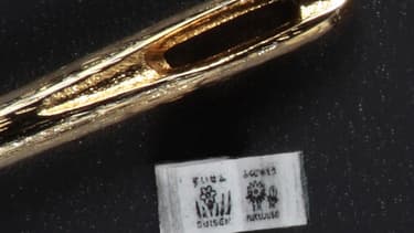 Le micro-livre "Fleurs de saisons", à côté d'une aiguille.