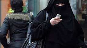 Une femme portant le voile intégral dans une rue de Saint-Denis, en banlieue parisienne. Les députés examinent à partir de mardi soir le projet de loi d'interdiction de la burqa, auquel seuls les élus Verts et communistes s'opposent. /Photo d'archives/REU