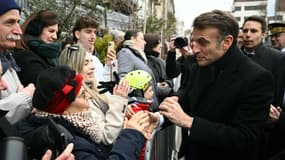 Emmanuel Macron salue les gens dans la rue après avoir assisté à la cérémonie de commémoration du 80e anniversaire de la libération par les Alliés de la ville de Colmar, dans l'est de la France, à la fin de la Seconde Guerre mondiale, à Colmar, le 2 février 2025.