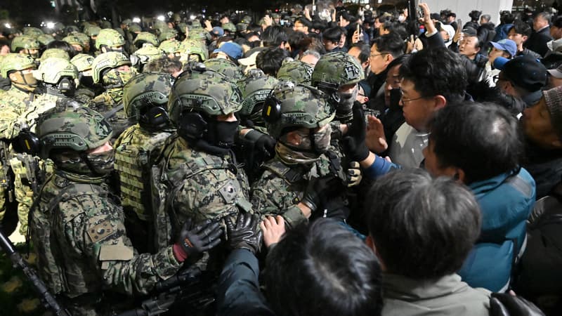 Des soldats tentent de pénétrer dans le bâtiment de l'Assemblée nationale à Séoul, le 4 décembre 2024, après que le président sud-coréen Yoon Suk Yeol a déclaré la loi martiale.