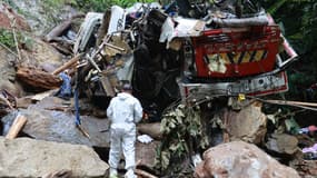 Un expert médico-légal se tient sur les lieux où un bus a fait une sortie de route, faisant 17 morts et 20 blessés, près de la municipalité de Remedios, dans le département d'Antioquia, en Colombie, le 14 décembre 2025.
