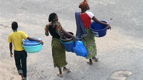 Habitants d'Abidjan à la recherche d'eau, jeudi. La poursuite des combats à Abidjan fait peser la menace d'un désastre sanitaire sur les quatre millions d'habitants de la capitale économique ivoirienne, confrontés à une pénurie de médicaments et à des cou