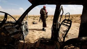 Un insurgé libyen après un raid de la coalition sur une route entre Ajdabiah et Brega. Une dizaine de rebelles ont péri vendredi soir dans un raid de la coalition internationale sur le front de l'Est libyen où les forces loyalistes ont à nouveau progressé