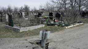 Une roquette non éclatée fichée dans le sol d'un cimetière à Mykolaïv, dans le sud de l'Ukraine, le 21 mars 2022
