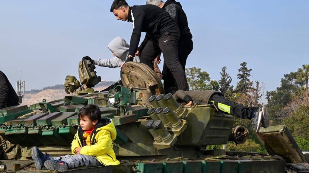 Des enfants explorent un tank abandonné sur la place des Omeyyades à Damas, en Syrie, le 10 décembre 2024. Des enfants explorent un tank abandonné sur la place des Omeyyades à Damas, en Syrie, le 10 décembre 2024.