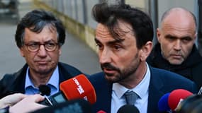 Le maire de Lyon, Gregory Doucet (au centre), s'adresse à la presse, entouré de son avocat, Didier Seban (à gauche), après avoir été remis en liberté après plus de 10 heures d'interrogatoire dans le cadre d'une enquête pour détournement de fonds publics, à la préfecture de police de Lyon, le 9 avril 2025.