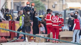 Des migrants débarquent en Sicile après avoir été aidés par des membres de la Croix-Rouge à quitter le navire Sea Eye 4 de l'ONG allemande Sea Eye, le 7 novembre 2021.