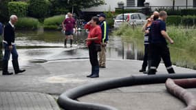 A Bilzen, ville belge, des habitants tentent de drainer l'eau dans une rue inondée, le 2 juin 2016. (Photo d'illustration) 