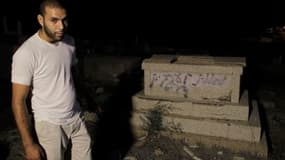 Un homme devant une sépulture couverte de graffitis à Jaffa. Des dizaines de pierres tombales d'un cimetière musulman et chrétien ont été profanées par des inconnus dans cette ville d'Israël, samedi, jour du Yom Kippour (Grand pardon). /Photo prise le 8 o