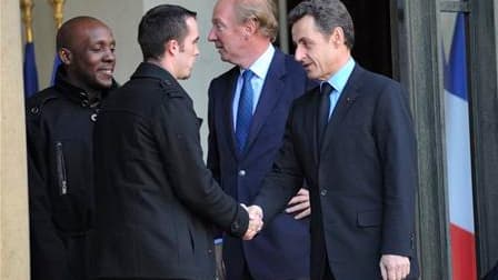 Nicolas Sarkozy serre la main de Jonathan Pigeon (deuxième à gauche), chauffeur d'un bus attaqué mercredi à Tremblay-en-France, en Seine-Saint-Denis. Dans un communiqué, le chef de l'Etat a appelé les forces de l'ordre à "intensifier les opérations coup d