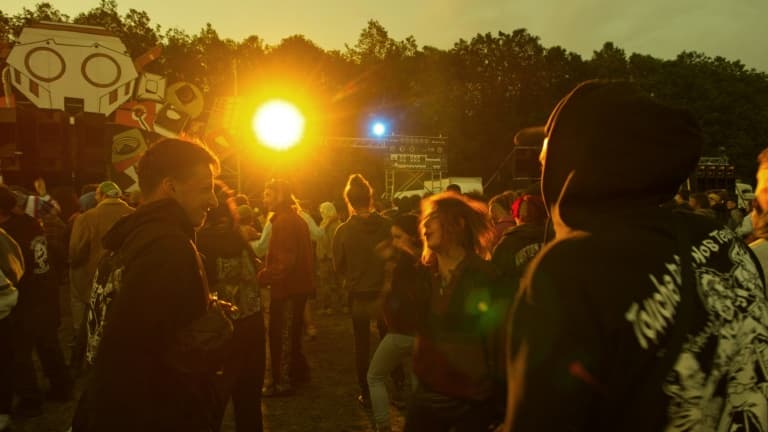 Des participants au Teknival dansent le 18 mai 2023 à Villegongis, dans l'Indre