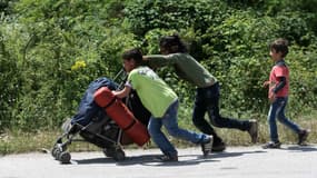 Des enfants migrants quittent le camp d'Idomeni, à la frontière entre la Grèce et la Syrie, le 25 mai 2016. (Photo d'illustration) 