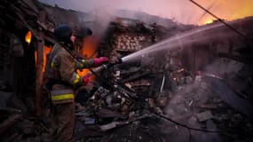 Sur cette photo prise et diffusée par les services d'urgence ukrainiens le 17 novembre 2024, un secouriste ukrainien s'efforce d'éteindre un incendie dans un bâtiment à la suite d'une attaque de drone à Mykolaïv. 