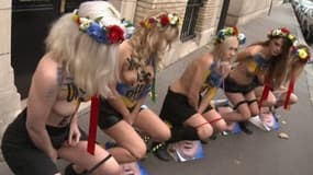 Des Femen urinent sur la photo du président Viktor Ianoukovitch devant l'ambassade ukrainienne dans le VIIe arrondissement de Paris le 1er décembre 2013.