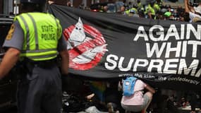 Des manifestants anti-racistes abrités derrière une barrière pour soigner leurs blessés, le 12 août 2017 à Charlottesville aux Etats-Unis. 