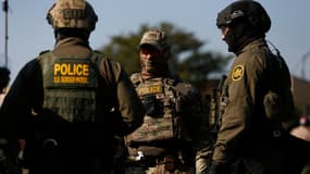 Des agents des douanes et de la protection des frontières américaines (CBP) montent la garde alors que des centaines de manifestants se rassemblent près d'un centre de l'ICE (Immigration and Customs Enforcement) à Broadview, dans l'Illinois, le 3 octobre 2025.