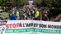 Des manifestants brandissent une banderole sur laquelle on peut lire "Arrêtez l'A69 et son monde, une autre voie est possible" lors d'une manifestation contre le projet d'autoroute A69 reliant Toulouse à la ville de Castres, à Toulouse, dans le sud-ouest de la France, le 21 avril 2024.
