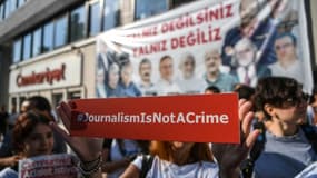 Une journaliste brandit une pancarte disant "le journalisme n'est pas un crime", lors d'un rassemblement devant le siège du quotidien d'opposition Cumhuriyet à Ankara, le 24 juillet 2017