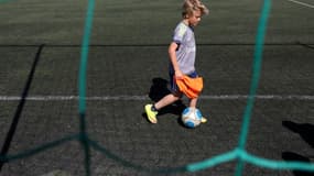 Un enfant joue au football sur du gazon artificiel en Croatie en avril 2016