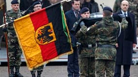 Le ministre de la Défense allemand Karl-Theodor zu Guttenberg (au centre) et son homologue français Alain Juppé (à droite), lors de la cérémonie d'installation d'une unité d'infanterie allemande à Illkirch-Graffenstaden, dans la banlieue de Strasbourg. Ce