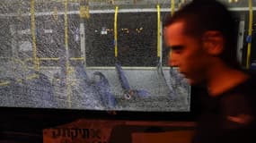 Un homme passe devant un bus criblé de balles. Les tirs ont fait au moins 7 blessés, à Jérusalem, en Israël, le 14 août 2022