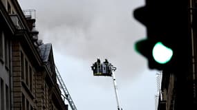 Des pompiers tentent d'éteindre l'incendie qui a pris au dernier étage, en travaux, du Ritz, place Vendôme à Paris le 19 janvier 2015.
