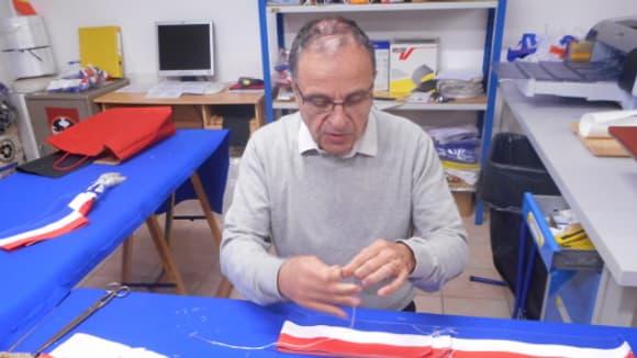 Patrick Varinard à l'oeuvre. L'ensemble de l'assemblage d'une écharpe tricolore est réalisé à la main.
