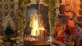 Le roi Maha Vajiralongkorn allume une bougie devant le portrait de son père, le roi défunt Bhumibol Adulyadej, lors de ses funérailles, le 26 octobre 2017 à Bangkok