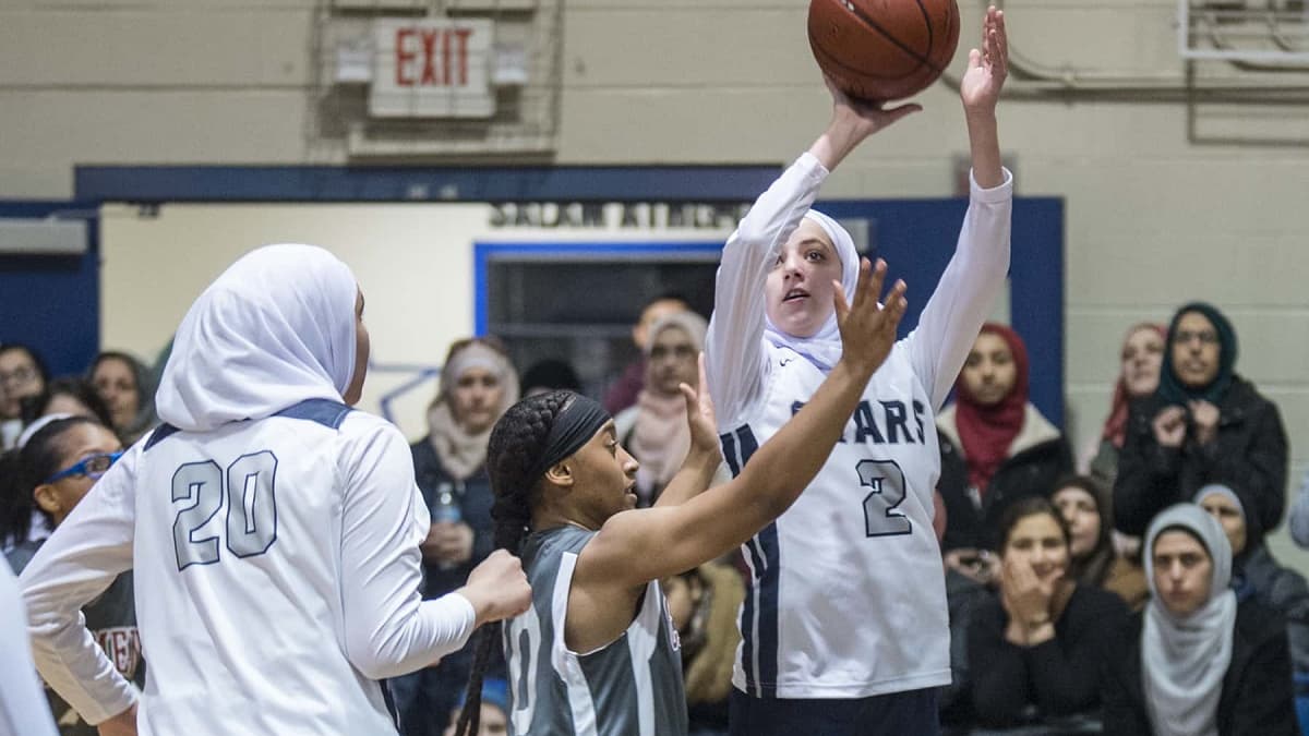 Une joueuse de la Salam High School (en blanc) au tir lors d'un match Une joueuse de la Salam High School (en blanc) au tir lors d'un match