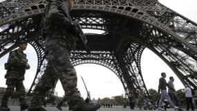 Des militaires patrouillent devant la Tour Eiffel.