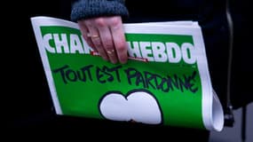 Une personne tient le dernier numéro de Charlie Hebdo, qui comporte une caricature de Mahomet en Une.