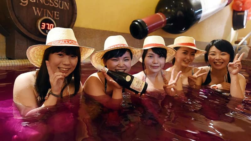 Des Japonaises posant dans un spa rempli de Beaujolais nouveau
