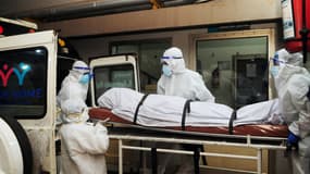 Photo prise le 12 septembre 2023 où des agents  déplacent le corps d'une personne décédée d'une infection par le virus Nipah dans un hôpital privé de Kozikode (Inde).