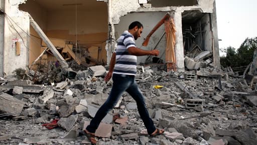 Un homme traverse les ruines d'une mosquée détruite par un raid aérien, dans un camp de réfugiés de la bande de Gaza.