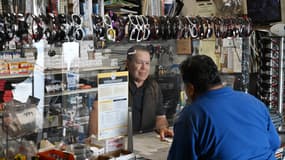 Marcos Ochoa, propriétaire de Marcos Hardware and Garden Supply, discute avec un client dans son magasin de la vallée de San Fernando à Los Angeles, en Californie, le 15 avril 2025. Propriétaire d'une petite quincaillerie et de produits de jardinage, il explique que les gens "deviennent fous" face à l'incertitude entourant les droits de douane imposés par le président américain Donald Trump. 