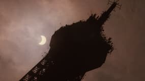Vue partielle de l'éclipse du soleil derrière la Tour Eiffel, le 11 août 1999 à Paris (France), où 14 000 À 15 000 personnes se sont rassemblées sur le Champ de Mars pour admirer cette éclipse, la dernière du millénaire sur le continent européen. (Photo d'illustration)